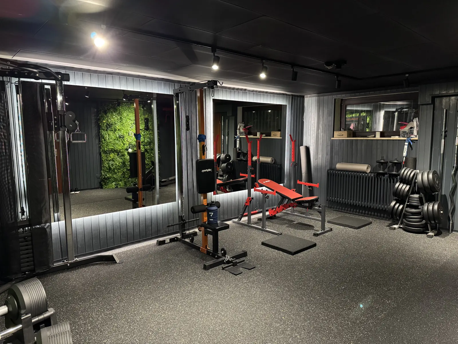 Krafttrainingsbereich mit Spiegeln, Bank und Hanteln